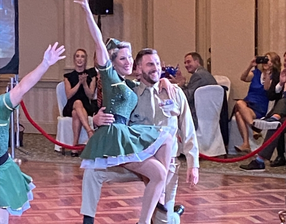 dancing man in tan and woman in green on wood floor
