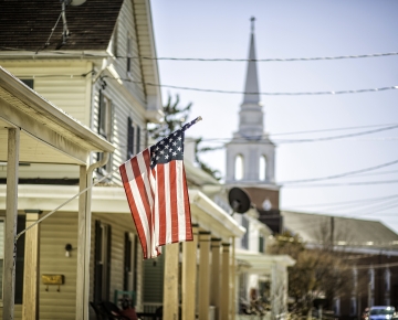 American flag with buildings in the background