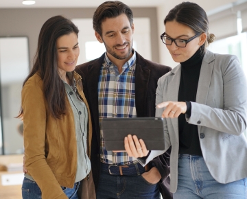 couple in home looking at tablet with realtor