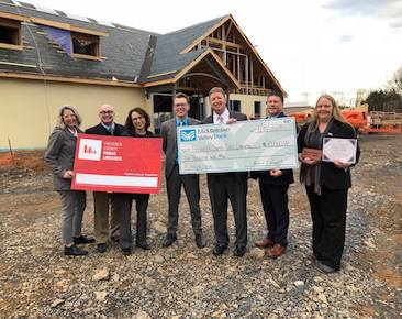 Employees Presenting a Giant Check at Job Site
