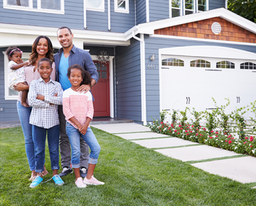 Family of four in front of blue house