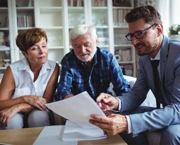 elderly couple looking at papers with man in suit