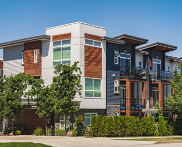white, brown, blue, and gray condo complex with trees